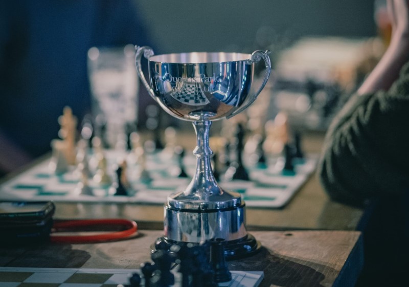 The Queens Park Club Championship trophy next to several chessboards.